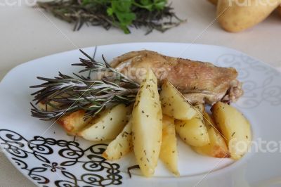 Baked potatoes and chicken with rosemary