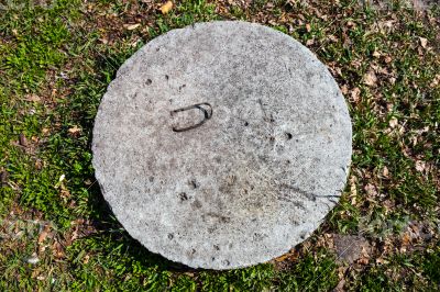 Concrete manhole cover in the grass