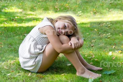 Cute girl sitting on green grass Cute girl sitting on green grass