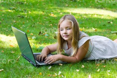 Cute girl with laptop on green grass Cute girl with laptop on green grass