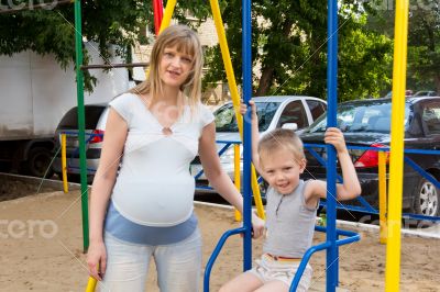 Pregnant mother and son on seesaw