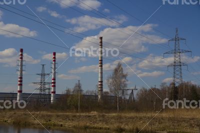 Factory pipes and high voltage power lines against the blue sky 