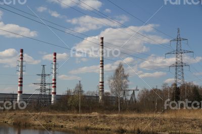 Factory pipes and high voltage power lines against the blue sky 