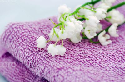 Spa setting of  towels, soap and lilies of the valley 