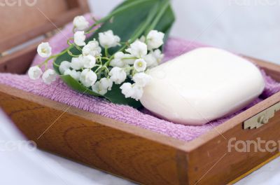 Spa setting of  towels, soap and lilies of the valley 