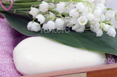 Spa setting of towels, soap and lilies of the valley 