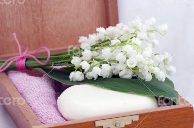 Spa setting of towels, soap and lilies of the valley 