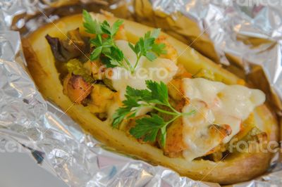 Baked jacket potato with vegetables,chicken filet,fresh parsley 