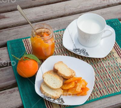 Homemade tangerine marmalade on the small square dessert plate