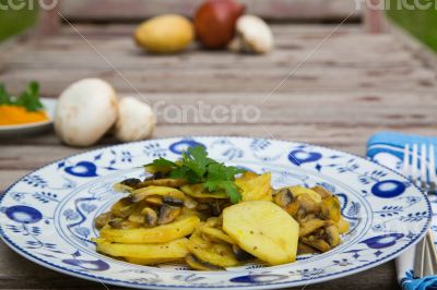 Baked potatoes with mushrooms and parsley on the white blue plat