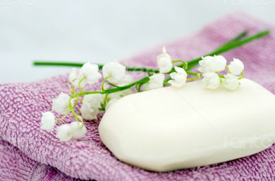 Spa setting of towels, soap and lilies of the valley