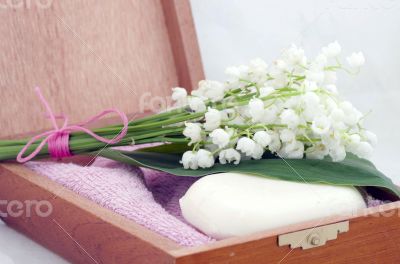 Spa setting of towels, soap and lilies of the valley 