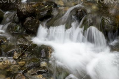 Small mountain waterfall among the rocks. 