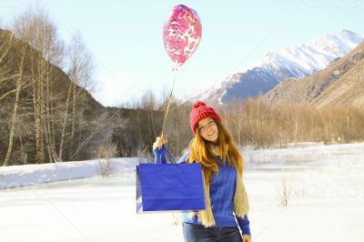 cheerful girl with a balloon and a package 