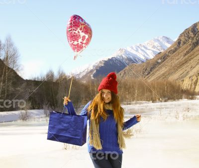 cheerful girl with a balloon and a package 