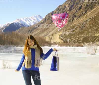 Happy girl with a balloon and a package 