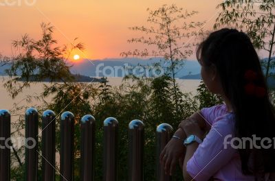 Happy young woman standing watching the sunset