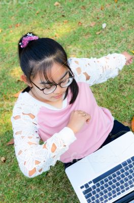 Cute girl is happy with notebook on grass