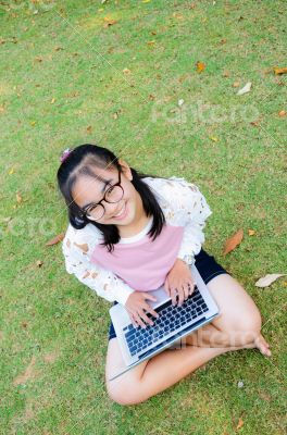 Lovely girl with a laptop on the grass