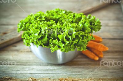 lettuce salad in metal bowl and carrots 