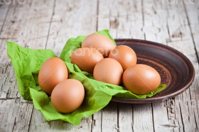  fresh brown eggs in plate and green napkin