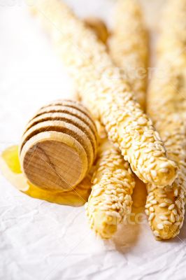 grissini with sesame seeds and honey dipper