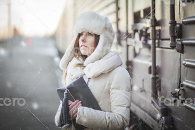 Pretty girl in winter blizzard on railroad station