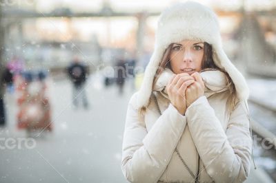 Youn woman on a train station in winter