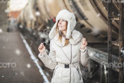 Pretty girl in winter blizzard on railroad station