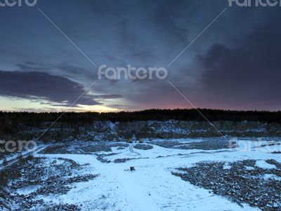 Snow covered stone quarry in the winter with all the tools and b