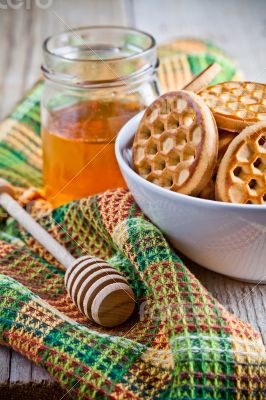 fresh cookies in a bowl, tablecloth and honey 