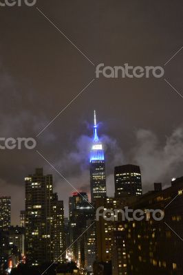 Empire state guilding between clouds