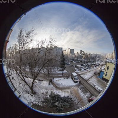 A view from the window on the winter city and houses  by fisheye view