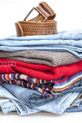 Pile of woolen jumpers and blue jeans