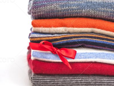 Pile of woolen jumpers of various colors and textures 