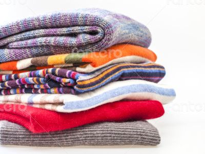 Pile of woolen jumpers of various colors and textures 