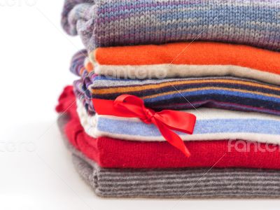 Pile of woolen jumpers of various colors and textures 