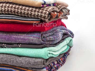 Pile of woolen jumpers of various colors and textures