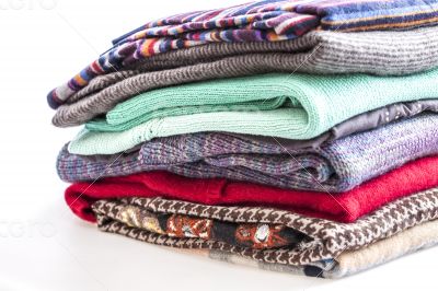 Pile of woolen jumpers of various colors and textures