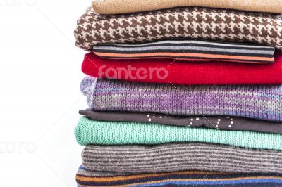 Pile of woolen jumpers of various colors and textures