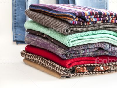 Pile of woolen jumpers of various colors and textures