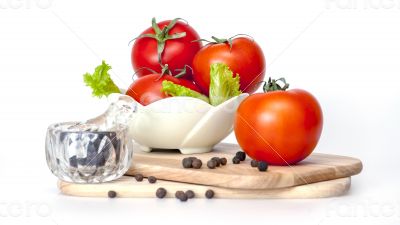 Red juicy tomatoes, lettuce leaves and black pepper