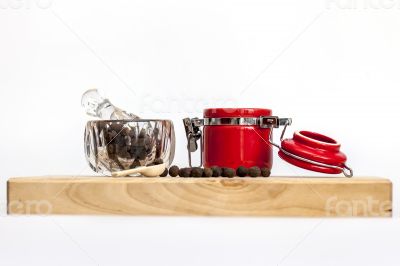 Black pepper in a transparent mortar and container for spices