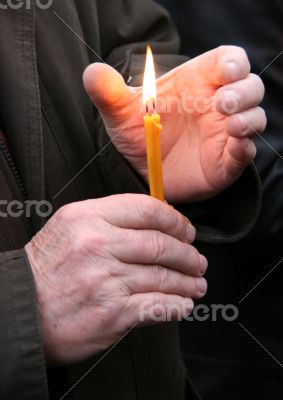 Flaming candle upon palms protection