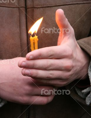 Flaming candle upon palms protection