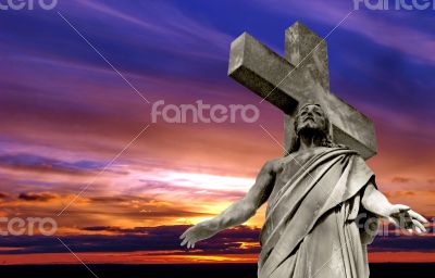 crucified Jesus Christ against dramatic sunset