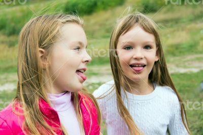 Cute two playing girls put out tongues Cute two playing girls put out tongues