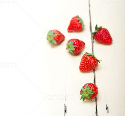 fresh organic strawberry over white wood