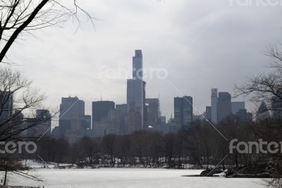 Midtown in winter from Central Park by and frozen podn Midtown in winter from Central Park by and frozen podn