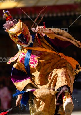 Buddhist monk in mask performs religious dancе